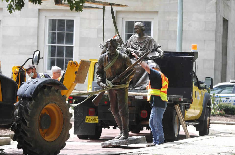 Crews add The Henry Wyatt Monument to a truck after removing them from the North Carolina State Capitol in Raleigh, N.C., Saturday, June 20, 2020. crews removed one statue dedicated to the women of the Confederacy, and another placed by the United Daughters of the Confederacy honoring Henry Wyatt, the first North Carolinian killed in battle in the Civil War. Both statues stood for over a century. It was not immediately clear who ordered the removals. (Ethan Hyman/The News & Observer via AP)