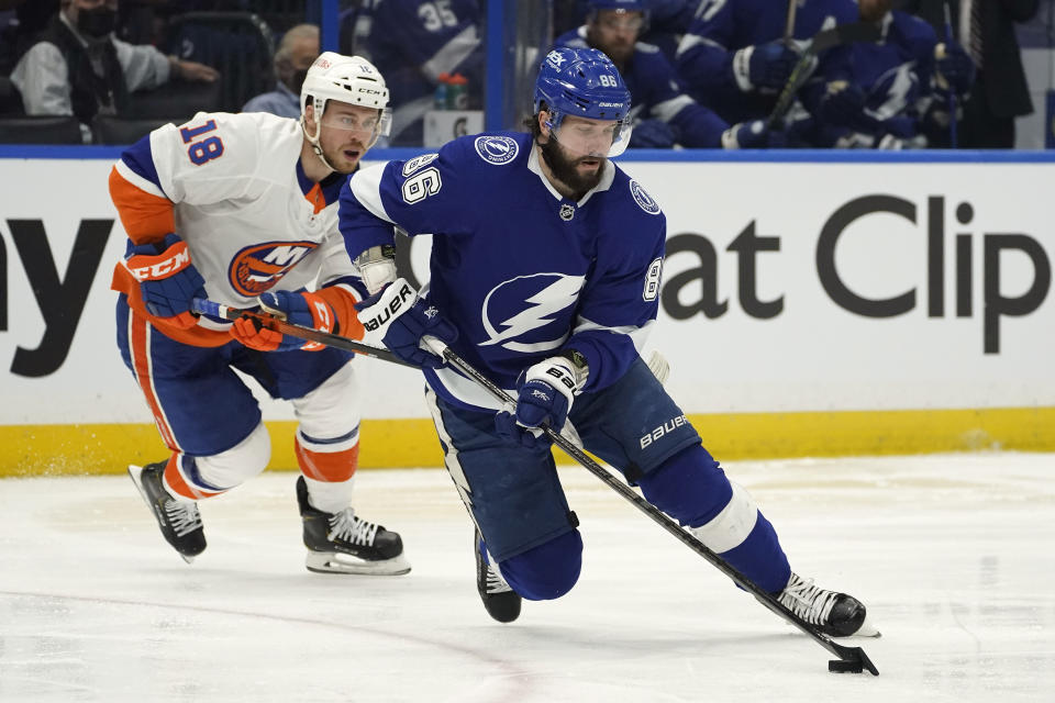 Tampa Bay Lightning right wing Nikita Kucherov (86) beats New York Islanders left wing Anthony Beauvillier (18) to a loose puck during the first period in Game 1 of an NHL hockey Stanley Cup semifinal playoff series Sunday, June 13, 2021, in Tampa, Fla. (AP Photo/Chris O'Meara)