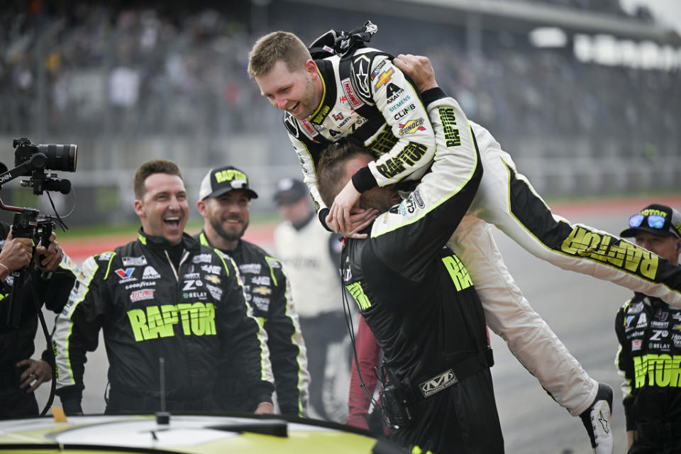 William Byron, top, is picked up by crew member Landon Walker in celebration of his win after a NASCAR Cup Series auto race on Sunday, March 24, 2024, at Circuit of the Americas in Austin, Texas. (AP Photo/Darren Abate)