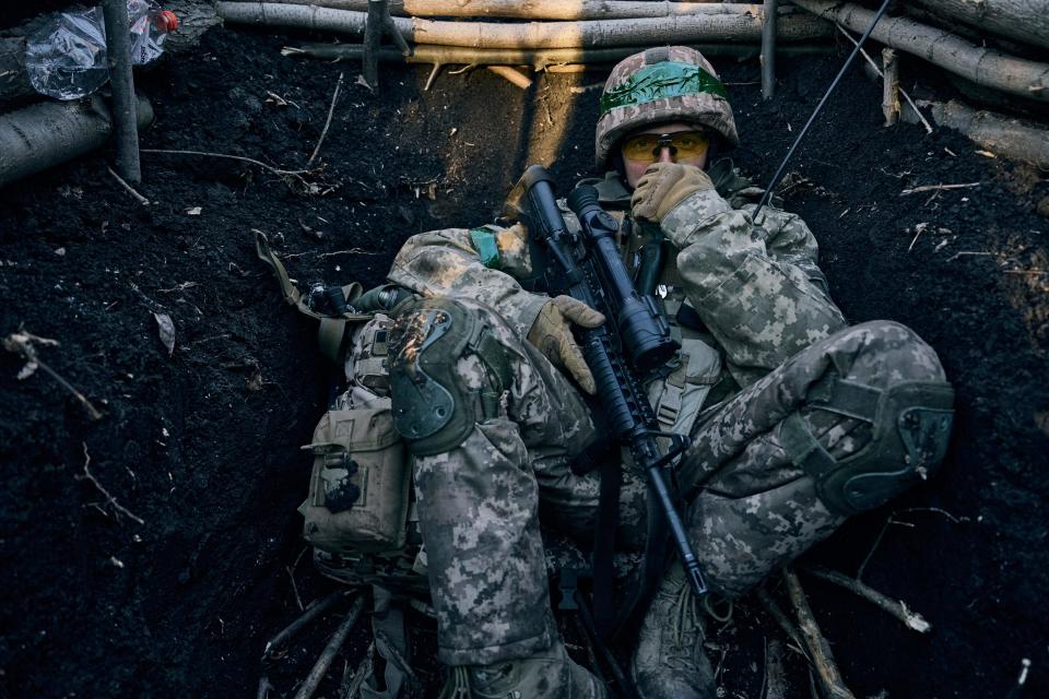 A Ukrainian soldier sits in a trench near Russian positions near Bakhmut, Donetsk region, Ukraine, Sunday, March 5, 2023.