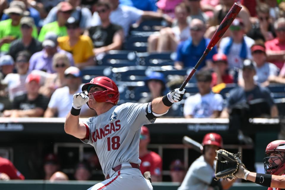 Jun 18, 2022; Omaha, NE, USA;  Arkansas Razorbacks right fielder Chris Lanzilli (18) launches a three-run home run in the fifth inning against the Stanford Cardinal at Charles Schwab Field. Mandatory Credit: Steven Branscombe-USA TODAY Sports