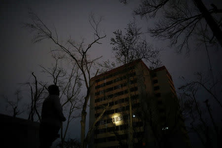 Carmen De Jesus uses a flashlight at the Moradas Las Teresas Elderly House, where about two hundred elderly people live without electricity following damages caused by Hurricane Maria in Carolina, Puerto Rico September 30, 2017. REUTERS/Carlos Barria