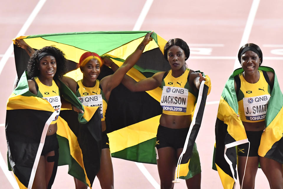 Natalliah Whyte, Shelly-Ann Fraser-Pryce, Shericka Jackson, and Jonielle Smith, from left to right, of Jamaica celebrate after winning the women's 4x100 meter relay final during the World Athletics Championships in Doha, Qatar, Saturday, Oct. 5, 2019. (AP Photo/Martin Meissner)