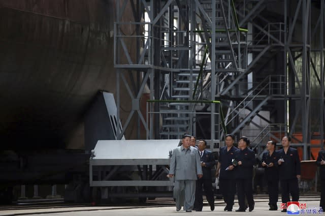 Kim Jong Un, left, inspects a newly built submarine