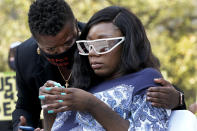 Deja Stallings, right, is comforted by her lawyer Stacy Shaw during a news conference outside city hall Thursday, Oct. 8, 2020, in Kansas City, Mo. Protesters have occupied the lawn and plaza in front of city hall more than a week demanding the resignation of police chief Rick Smith and the officer who knelt on Stallings' back while arresting the pregnant woman last week. (AP Photo/Charlie Riedel)