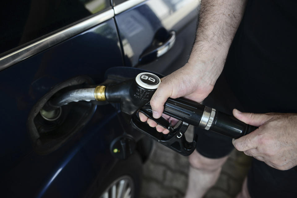 A man fills up his car at a petrol station in Budapest, Hungary, Sunday, June 12, 2022. Hungary has placed price caps on fuel and some food and imposed special taxes on industries as the government tries to ease an economic downturn and the highest inflation in nearly 25 years. (AP Photo/Anna Szilagyi)