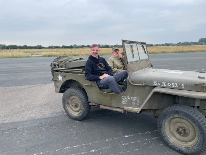 A man sits down in a jeep on a runaway.