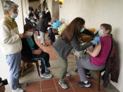 Registered nurse Liliana Ocampo, middle, administers a Moderna COVID-19 vaccine to retired nuns at The Sisters of St. Joseph of Carondelet independent living center in Los Angeles, Wednesday, March 3, 2021. Boys & Girls Clubs of W. San Gabriel Valley's mobile Pop-up RV in partnership with Monterey Park Hospital AHMC, help administer the vaccine to 50 retired nuns. (AP Photo/Damian Dovarganes)