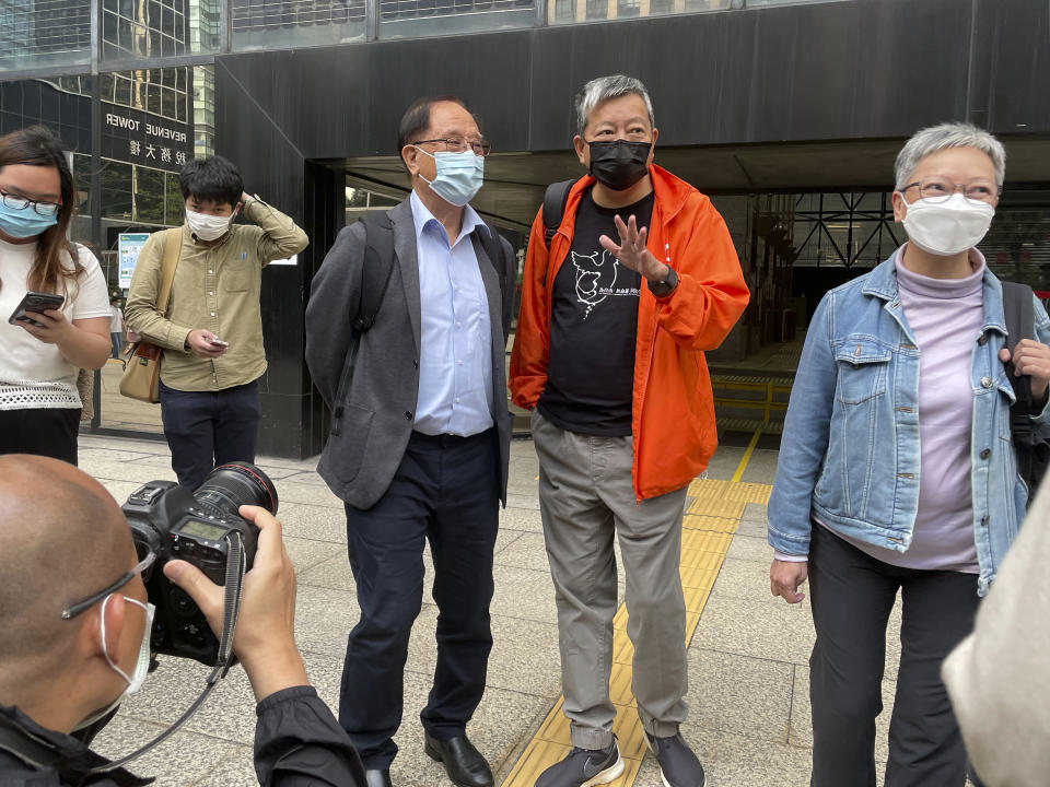 Pro-democracy activists Lee Cheuk-yan, second from right, and Yeng Sum, a former chairman of the Democratic Party, third from right, speak to media after being released on bail at a court in Hong Kong, Wednesday, April 7, 2021. Three veteran Hong Kong pro-democracy activists, including well-known publisher Jimmy Lai, have pleaded guilty to taking party in an unauthorized rally that resulted in violence between police and participants, media reported Wednesday. (AP Photo/Rafael Wober)
