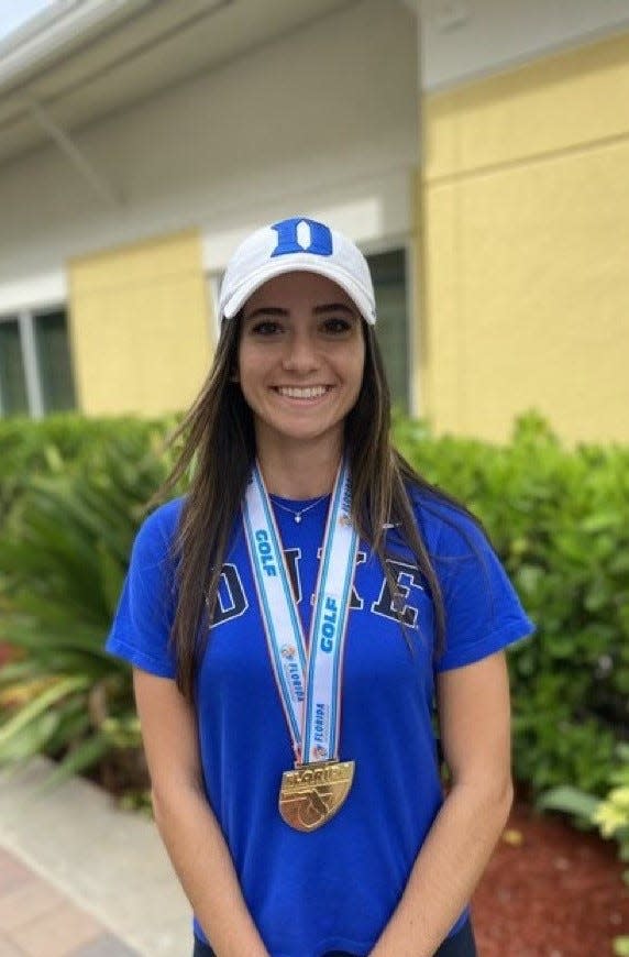 Benjamin School senior Andie Smith poses with her Class 1A state championship medal as well as Duke University gear in November 2021. Smith, who was first offered by the Blue Devils when she was 15, signed with Duke this fall.