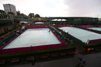 LONDON, ENGLAND - JULY 29: Rain covers protect the courts as rain delays play on Day 2 of the London 2012 Olympic Games at the All England Lawn Tennis and Croquet Club in Wimbledon on July 29, 2012 in London, England. (Photo by Clive Brunskill/Getty Images)