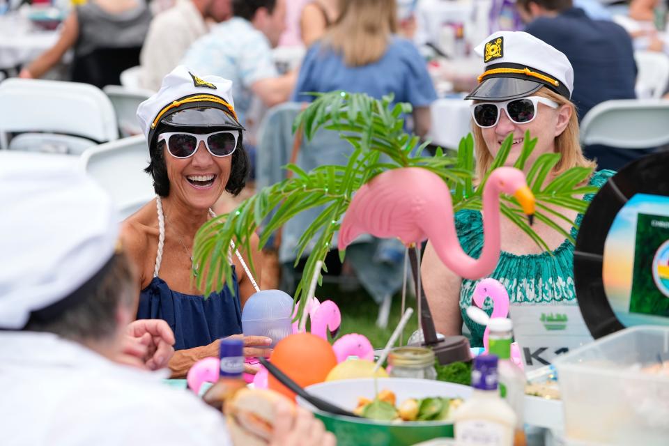 Debbie Ogden, left, of Dublin, and Nancy March of Upper Arlington have dinner with several friends as they wait for musician Christopher Cross during Picnic With the Pops Saturday night.