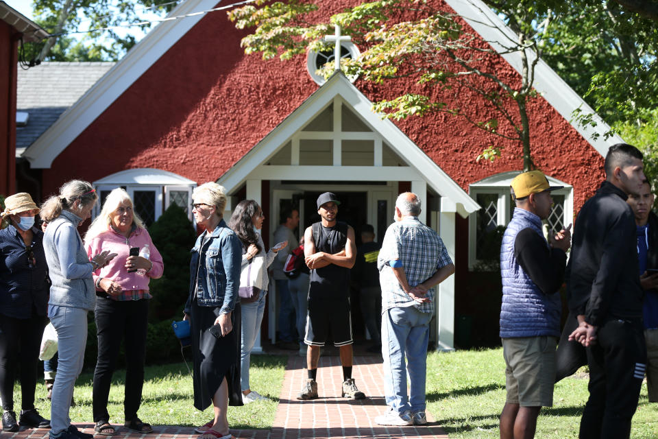 Volunteers mingle with some of the migrants outside St. Andrew's Episcopal Church. 