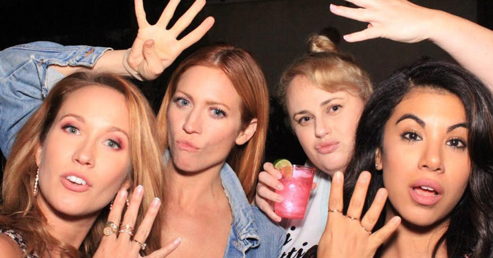 Anna Camp, Brittany Snow, Rebel Wilson and Chrissie Fit hold up their hands with a number 4