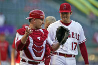 Los Angeles Angels catcher Max Stassi, left, talks to starting pitcher Shohei Ohtani before the team's baseball game against the Seattle Mariners on Monday, Aug. 15, 2022, in Anaheim, Calif. (AP Photo/Marcio Jose Sanchez)