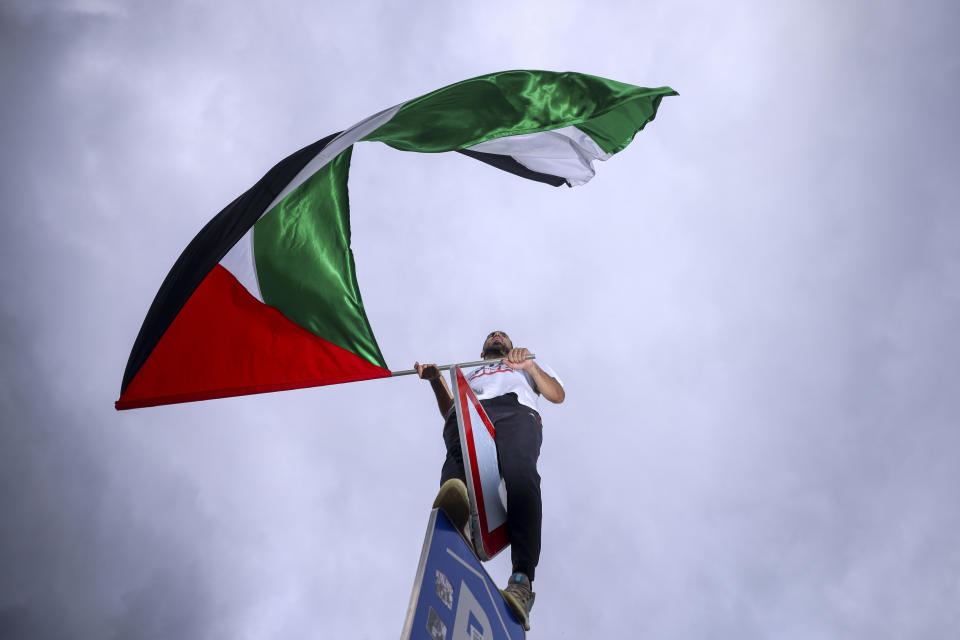 A Bosnian man waves a Palestinian flag during a protest against Israel and in support of Palestinians in Sarajevo, Bosnia, Sunday, Oct. 22, 2023. (AP Photo/Armin Durgut)