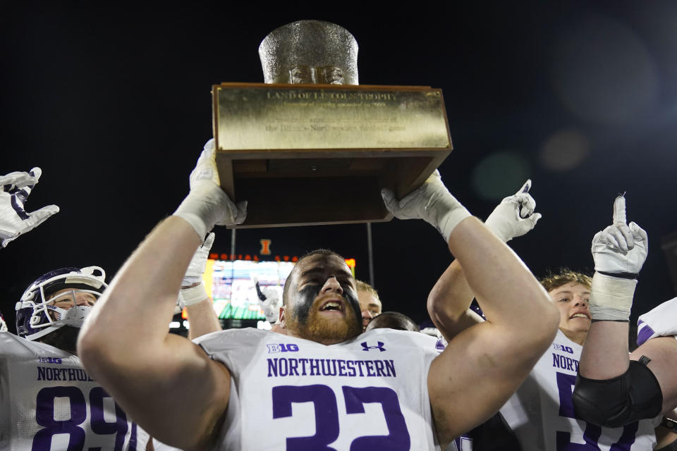 Northwestern linebacker Bryce Gallagher holds up the Land of Lincoln Trophy after his team defeated Illinois in an NCAA college football game Saturday, Nov. 25, 2023, in Champaign, Ill. (AP Photo/Erin Hooley)