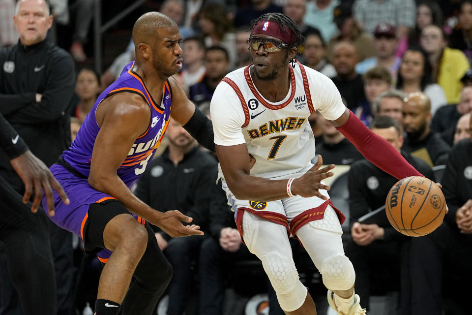 Denver Nuggets guard Reggie Jackson (7) drives as Phoenix Suns guard Chris Paul defends during the first half of an NBA basketball game, Friday, March 31, 2023, in Phoenix. (AP Photo/Matt York)