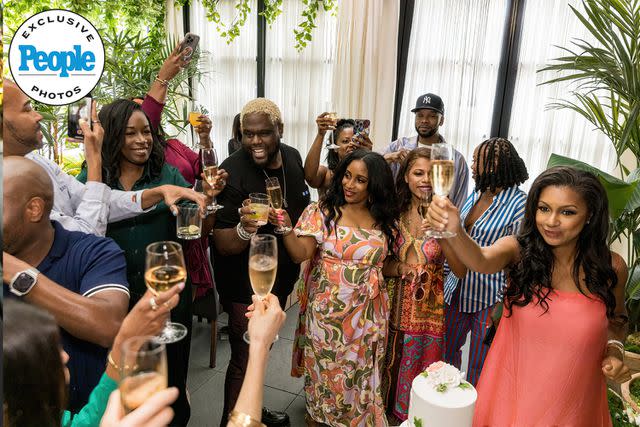 <p>Ken Jones Photography</p> Eboni K. Williams does a champagne toast with her baby shower guests