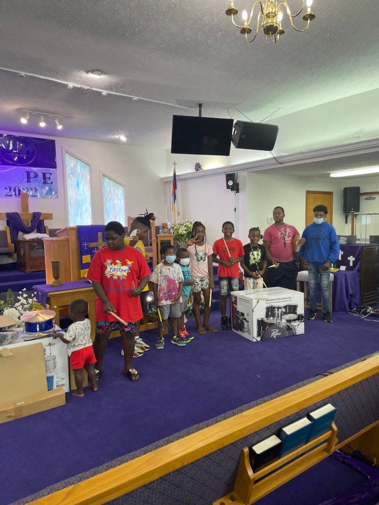 Attendees of Saturday's event put on by The Antwain Hoskins Foundation gather with their new drumsticks and a free drum kit.