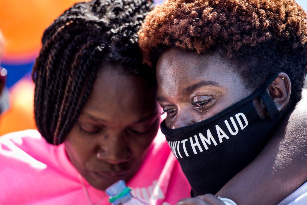 Jasmine Arbery, sister of Ahmaud Arbery (R) and Wanda Cooper-Jones, Ahmaud's mother, comfort one another while people gather to honor Ahmaud at Sidney Lanier Park on May 9, 2020 in Brunswick, Georgia. Arbery was shot and killed while jogging in the nearby Satilla Shores neighborhood on February 23. 