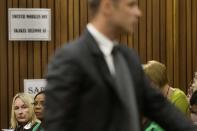 Reeva Steeenkamp's mother June (back L) looks on as Olympic and Paralympic track star Oscar Pistorius stands in the dock during court proceedings at the North Gauteng High Court in Pretoria March 18, 2014. Pistorius is on trial for murdering his girlfriend Steenkamp at his suburban Pretoria home on Valentine's Day last year. REUTERS/Marco Longari/Pool (SOUTH AFRICA - Tags: SPORT ATHLETICS CRIME LAW)