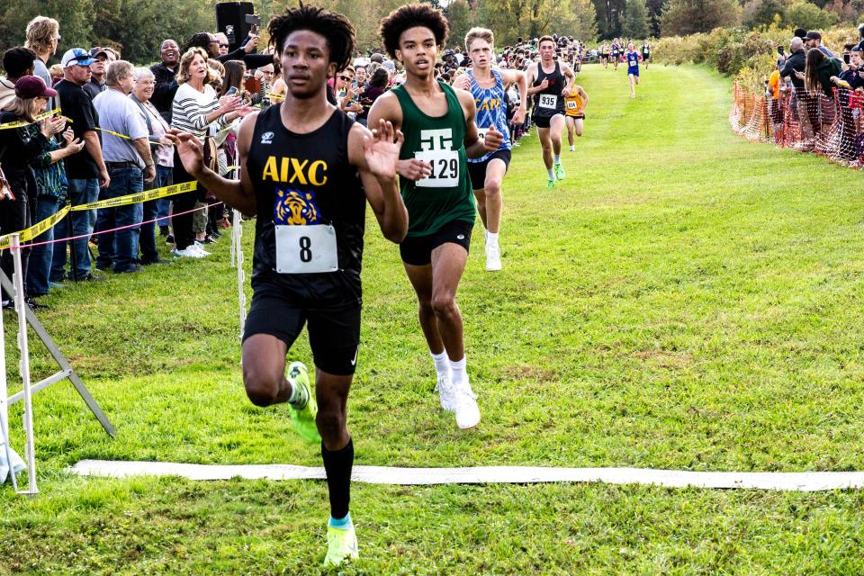 A.I. du Pont's Camerin Williams (8) finishes first, with Tower Hill's Colby Twyman (1129) in second, Cape Henlopen's Jason Baker (182) in third and St. Andrew's Peter Bird in fourth in the boys varsity race at the Joe O'Neill Invitational cross country meet on Thursday at Bellevue State Park in Wilmington.