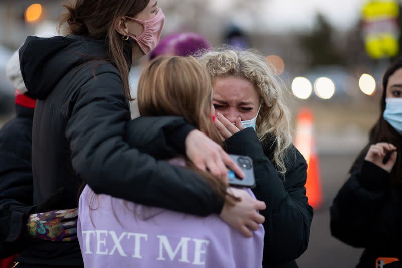 People at the site of a mass shooting at King Soopers grocery store in Boulder