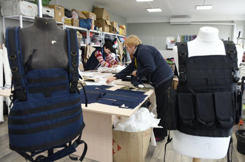 <span class="caption">Volunteers sew tactical military vests for the Ukrainian army in the western Ukrainian city of Lviv on March 4, 2022.</span> <span class="attribution"><a class="link " href="https://www.gettyimages.com/detail/news-photo/volunteers-sew-tactical-military-vests-for-the-ukrainian-news-photo/1238918869?adppopup=true" rel="nofollow noopener" target="_blank" data-ylk="slk:Yuriy Dyachyshyn/AFP via Getty Images;elm:context_link;itc:0;sec:content-canvas">Yuriy Dyachyshyn/AFP via Getty Images</a></span>