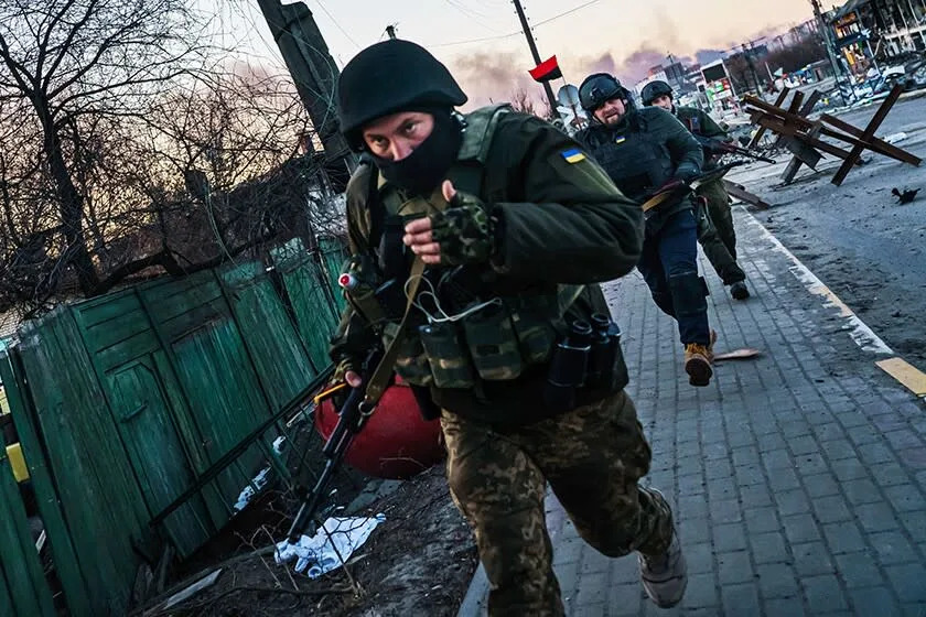 After fighting in Irpin, just outside the capital of Kyiv, Ukrainian soldiers run cautiously back toward safety from the front line.