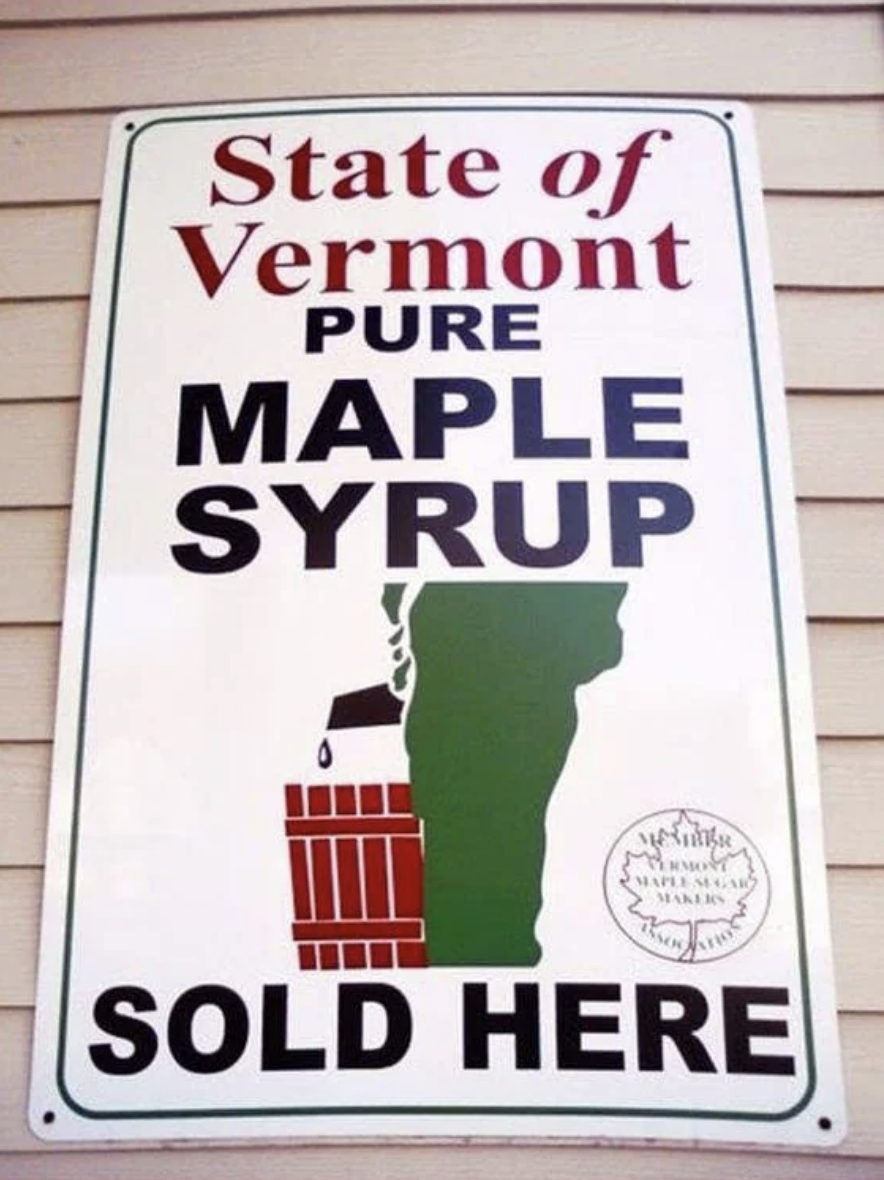 Un panneau indique "Sirop d'érable pur de l'État du Vermont vendu ici" avec un graphique d'un pot à sirop