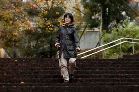 Translator Kaori Oguni, 41, walks down steps after an interview in Tokyo, Japan, December 3, 2015. REUTERS/Thomas Peter