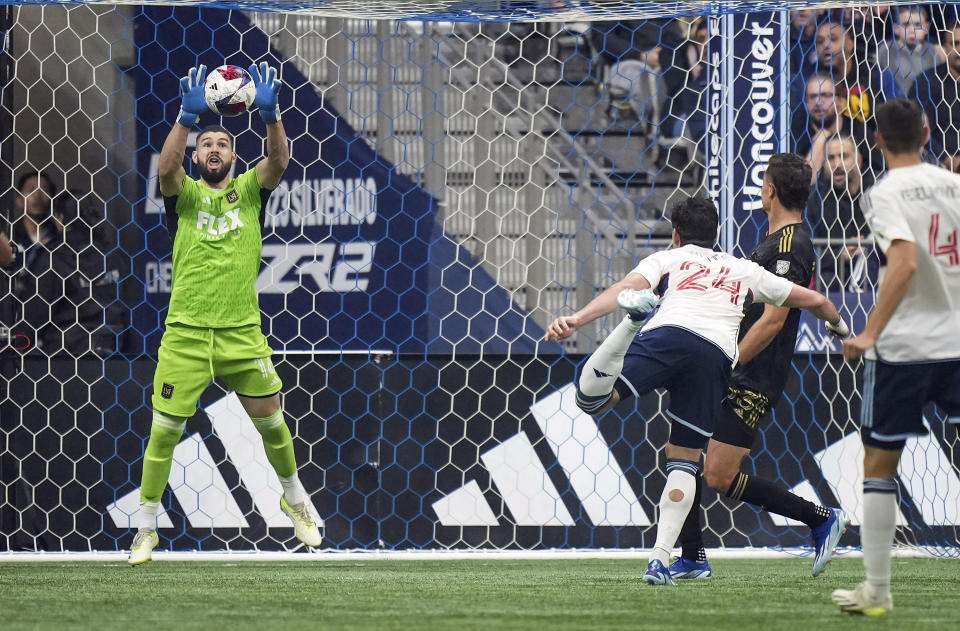 Los Angeles FC goalkeeper Maxime Crepeau, left, stops Vancouver Whitecaps' Brian White (24) during the second half in Game 2 of a first-round MLS playoff soccer match in Vancouver, British Columbia, Sunday, Nov. 5, 2023. (Darryl Dyck/The Canadian Press via AP)