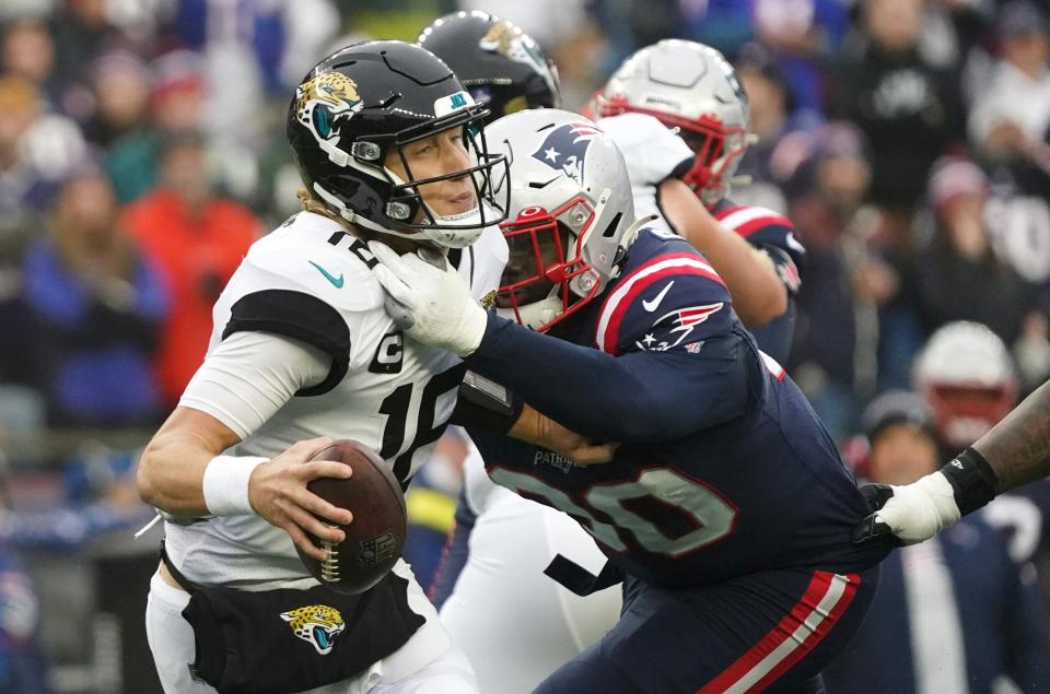 Jacksonville Jaguars quarterback Trevor Lawrence (16) is sacked by New England Patriots defensive end Christian Barmore (90)  on Jan 2, 2022, in Foxborough, Mass.