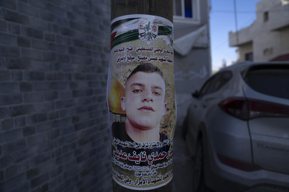 A poster with name and picture of Palestinian Ammar Adili, 22, who was shot and killed by an Israeli border police officer on Friday, is posted at a light pole in his home village of Osreen, south of West Bank city of Nablus, Saturday, Dec. 3, 2022. Palestinians pushed back Saturday against Israeli police claims that Ammar Adili had attacked Israelis, including a border policeman, in the area and that he was shot in self-defense. They said the officer killed Adili without cause, and that Palestinian medics were kept from trying to save him as he lay gravely wounded on the side of a busy throughfare in the occupied West Bank town of Hawara.(AP Photo/Nasser Nasser)