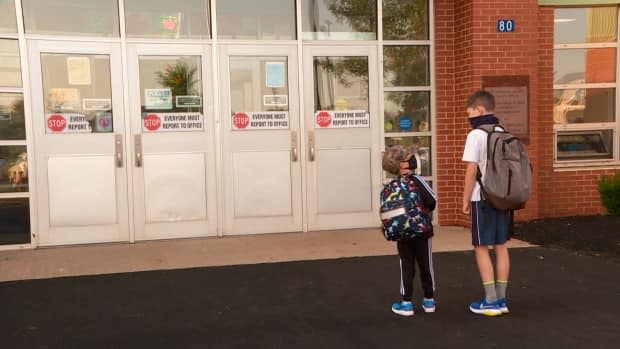 After two weeks in self-isolation, five-year-old Nolan Innis, left, and 11-year-old Blake Innis, right, were happy to head back to school Friday.  (Sheehan Desjardins/CBC - image credit)