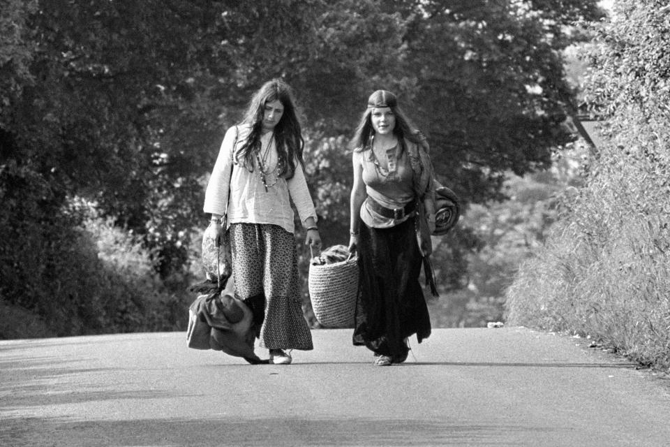 Happy hippies descend on the Glastonbury fields with their bags for the weekend in 1971.