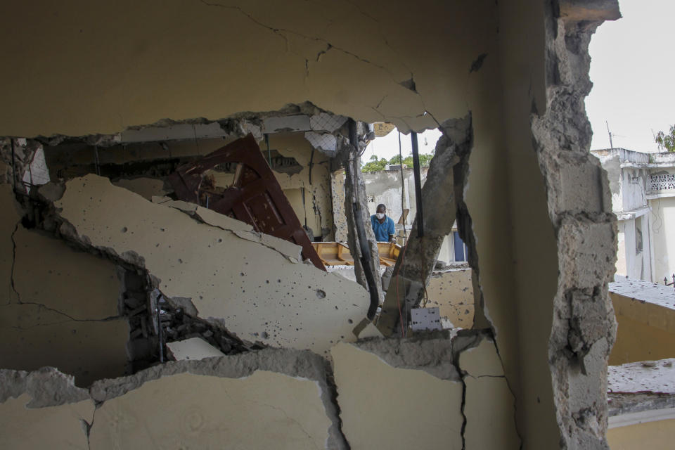 A man removes damaged furniture from the destroyed Hayat Hotel, days after a deadly siege by al-Shabab extremists, in Mogadishu, Somalia Wednesday, Aug. 24, 2022. The siege was the longest such attack in the country's history taking more than 30 hours for security forces to subdue the extremists, with more than 20 people killed. (AP Photo/Farah Abdi Warsameh)