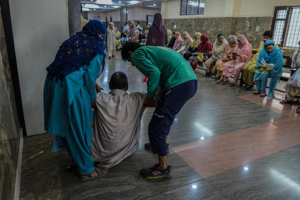 Family members help a patient inside the outpatient department (OPD) at a mental health hospital in Srinagar, Indian controlled Kashmir, Tuesday, Aug 1, 2023. Kashmir's mental healthcare clinics depict invisible scars of decades of violent armed insurrections, brutal counterinsurgency, unparalleled militarization, unfulfilled demands for self-determination have fueled depression and drugs in the disputed region, experts say. (AP Photo/Mukhtar Khan)