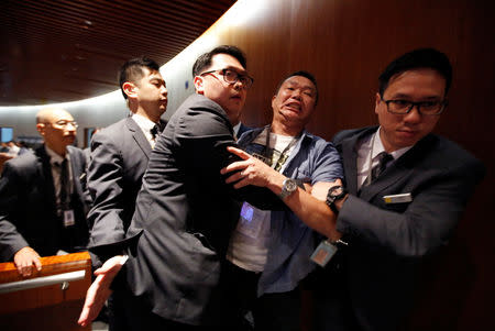 A protester shouting at Chief Executive Carrie Lam during her annual policy speech is taken away by security guards at the Legislative Council in Hong Kong, China October 10, 2018. REUTERS/Bobby Yip