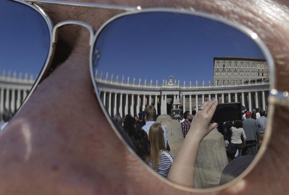 The Apostolic palace is reflected on the sunglasses of a man as faithful gather in St. Peter's Square during Pope Francis' Angelus noon prayer at the Vatican, Sunday, March 24, 2019. (AP Photo/Andrew Medichini)