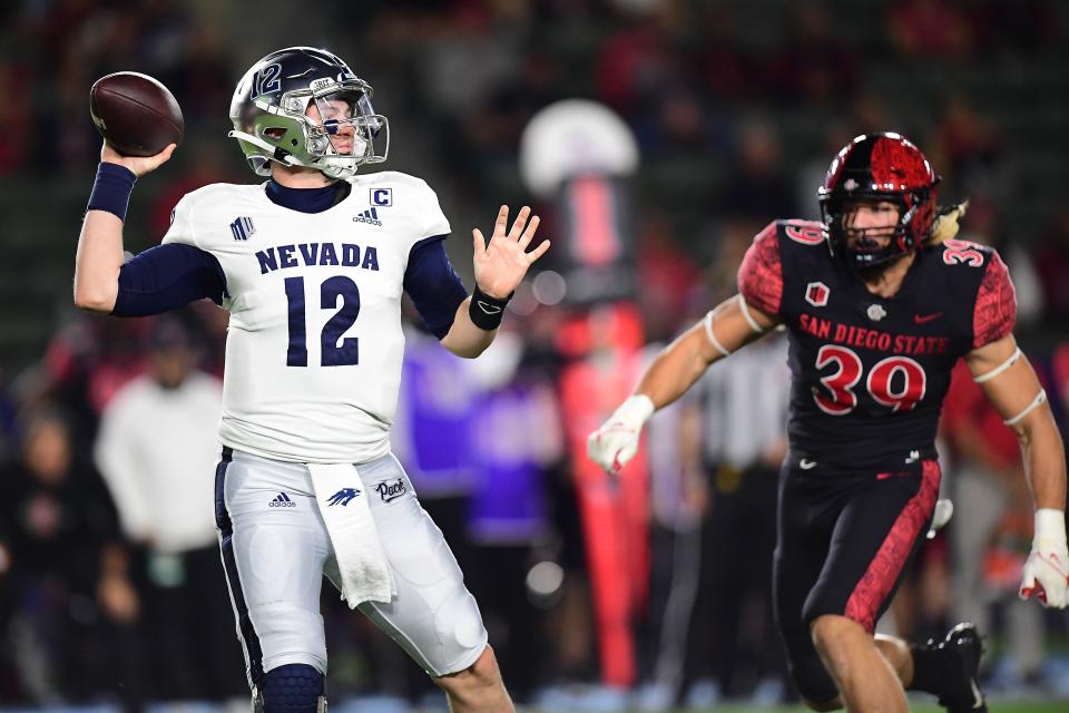 Nevada Wolf Pack quarterback Carson Strong (12) throws as San Diego State Aztecs linebacker Garret Fountain (39) moves in during the first half at Dignity Health Sports Park.