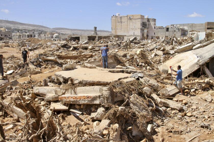 FILE - People look for survivors in Derna, Libya, on Sept.13, 2023. For years, experts warned that floods pose significant danger to dams protecting nearly 90,000 people in northeast of Libya, repeatedly calling for immediate maintenance to the two structures outside the city of Derna. But successive governments in the divided and chaos-stricken North African nation did not heed their advice. (AP Photo/Yousef Murad, File)