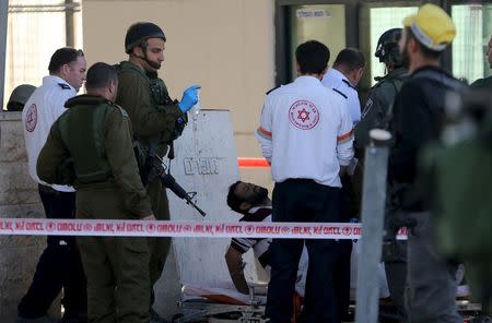 Israeli medics evacuate a Palestinian man, who a police spokeswoman said was shot and wounded by Israeli police during a car-ramming attempt at the West Bank checkpoint of Qalandia, near Ramallah, December 18, 2015. REUTERS/Mohamad Torokman