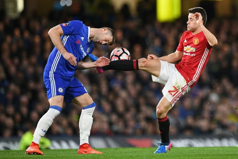 Chelsea's Gary Cahill (L) fights for the ball with Manchester United's Ander Herrera during their English FA Cup quarter-final match, at Stamford Bridge in London, on March 13, 2017