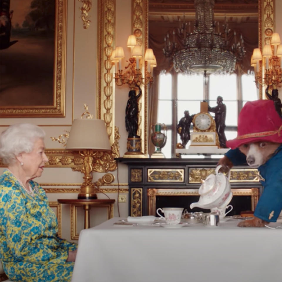 Paddington Bear, right, pours tea for Queen Elizabeth II in a video commemorating her Platinum Jubilee.  (YouTube)