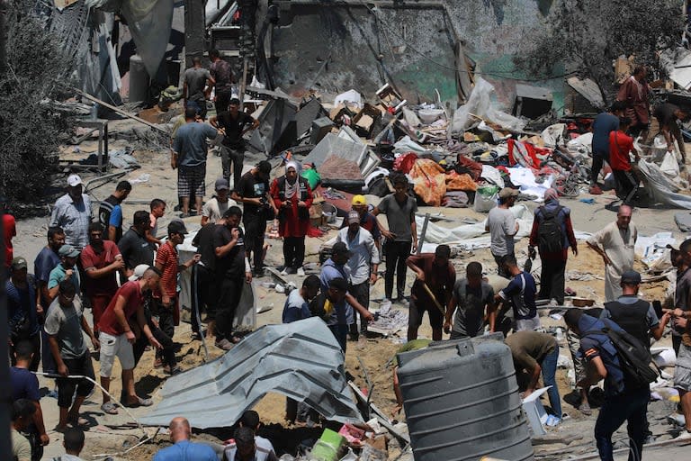 Palestinos buscan a sus seres queridos entre los escombros de tiendas y viviendas improvisadas tras un ataque militar israelí contra el campo de desplazados internos de Al Mawasi, cerca de la ciudad de Jan Yunis, en el sur de la Franja de Gaza, el 13 de julio de 2024, en el que murieron 71 personas. 