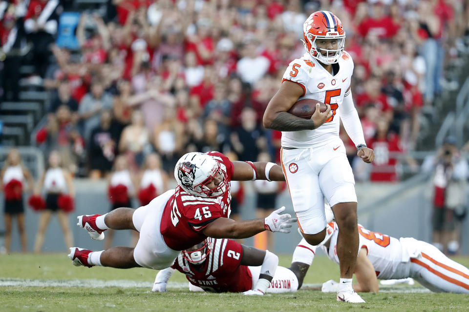 Clemson's D.J. Uiagalelei (5) runs away from North Carolina State's Davin Vann (45) during the second half of an NCAA college football game in Raleigh, N.C., Saturday, Sept. 25, 2021. (AP Photo/Karl B DeBlaker)