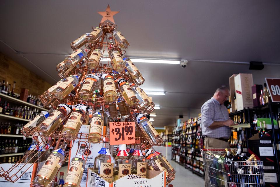 Derrik Wade, a wine salesman, organizes wines at Liquid Town on South Alameda Street on Thursday, Dec. 20, 2018.