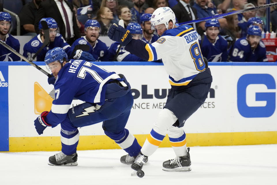 St. Louis Blues left wing Pavel Buchnevich (89) kicks the puck away from Tampa Bay Lightning defenseman Victor Hedman (77) during the first period of an NHL hockey game Tuesday, Dec. 19, 2023, in Tampa, Fla. (AP Photo/Chris O'Meara)